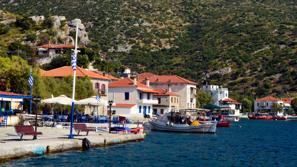 Pelion, Agia Kyriaki, Greece.  boats in water with buildsing in front of the mountains.