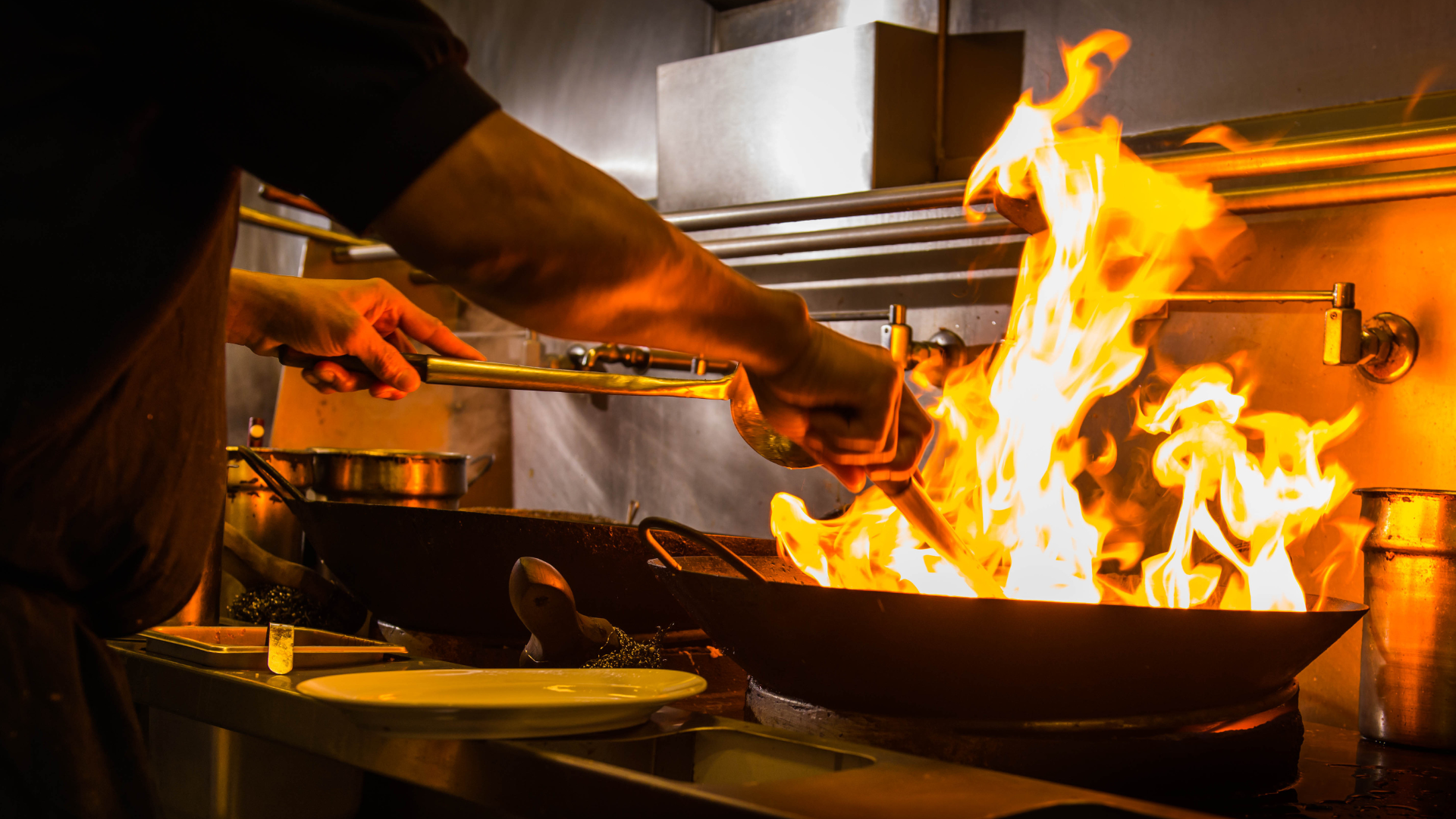 Chef creating a culinary masterpiece over fire in the kitchen - part of the recipe of food excellence when experiencing foodie travel.