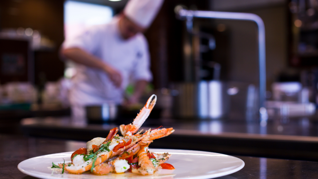 A plate of crab claws and a spot of cokctail sauce , displayed and ready to be served in a Michel-starred restaurant