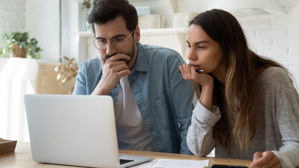 Coupleusing laptop to search for Travel Insurance information online